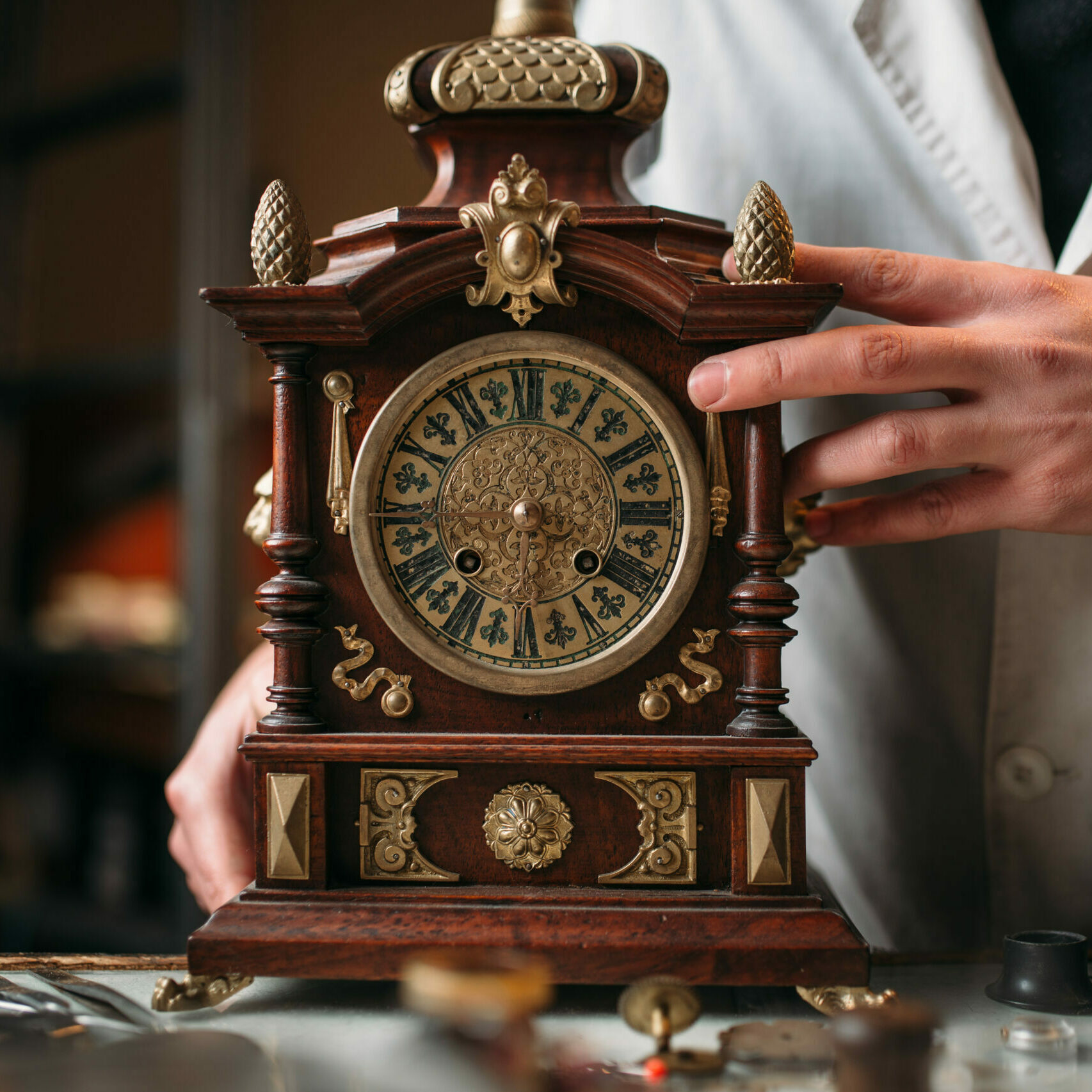 Watchmaker with old mechanical desk clock